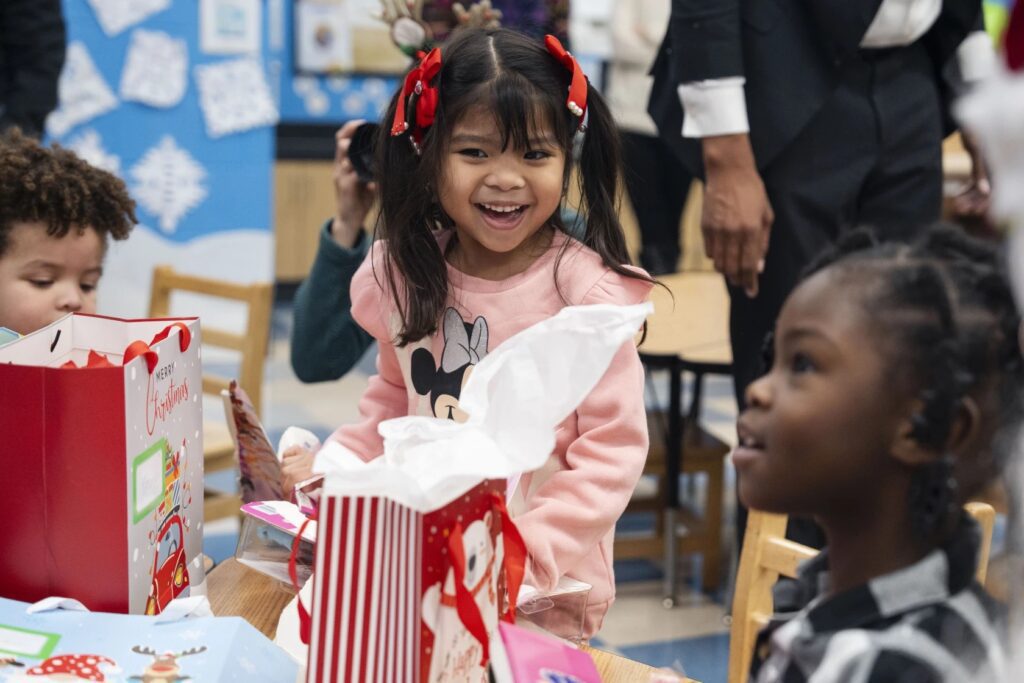 Keonah Cosicol (center) and her classmates open their gifts Friday at Jackie Robinson Elementary School on the South Side. Students from pre-K to third grade received Christmas gifts from the Children First Fund. Pat Nabong/Sun-Times